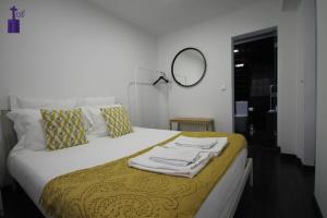 1 dormitorio con 1 cama con toallas en Lisbon North Apartment, en Lisboa
