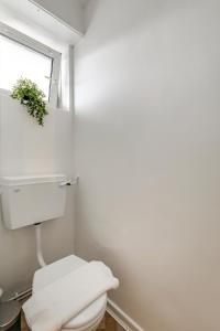 uma casa de banho com um WC branco e uma janela em Central NW1 London Apartment! em Londres