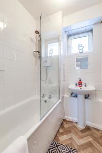uma casa de banho branca com um lavatório e um chuveiro em Central NW1 London Apartment! em Londres