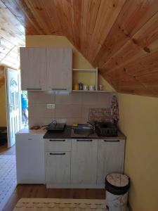 cocina con armarios blancos y techo de madera en Studio apartmani Anastasija, en Žabljak