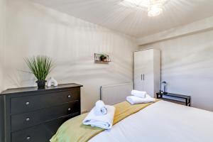 um quarto com uma cama, uma cómoda e toalhas em Central NW1 London Apartment! em Londres