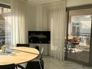 a dining room with a table and a balcony at Saint Jhon in Menton