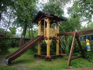 un parco giochi in legno con scivolo in erba di Котедж-шале Елітний a Slavske