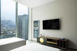 um quarto com uma cama e uma televisão na parede em Moderno departamento en Valle Poniente em Monterrey
