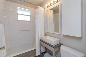 a bathroom with a sink and a toilet and a tub at Charming 1BR Vintage Treehouse Garage Apartment in Orlando