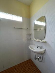 ein weißes Badezimmer mit Waschbecken und Spiegel in der Unterkunft Bangtao Hello House in Strand Bang Tao