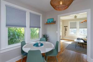 a dining room with a table and chairs and windows at Charming 1BR Vintage Treehouse Garage Apartment in Orlando