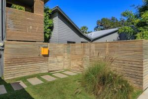 a wooden fence in front of a house at Charming 1BR Vintage Treehouse Garage Apartment in Orlando