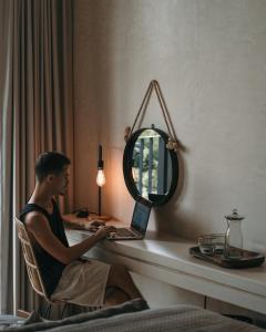 a man sitting at a desk with a laptop at Casa Agape Hotel Tulum & Vegan Restaurant with Beach Club Access in Tulum