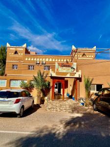 a building with cars parked in front of it at La Baraka Auberge in Aït Benhaddou