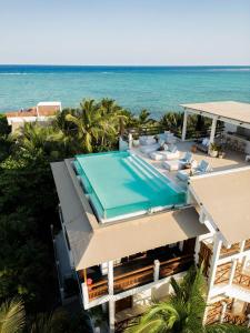 uma vista aérea de uma casa com uma piscina e o oceano em Jashita Hotel em Tulum