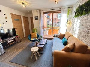 ein Wohnzimmer mit einem Sofa und einem TV in der Unterkunft Appartement Les Gets, 2 pièces, 4 personnes - FR-1-623-255 in Les Gets