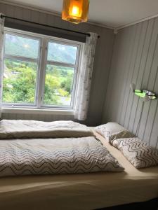 a bedroom with a bed and a window at Josygaard in Austefjorden