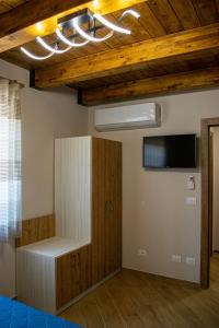 ヴィッジャネッロにあるL'Antica Fontana - Casa Vacanze B&Bのベッド1台と壁掛けテレビが備わる客室です。