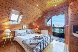 a bedroom with a large bed in a wooden wall at Scandi Cabin in Heart of Anglesey with Parking in Llanfairpwllgwyngyll