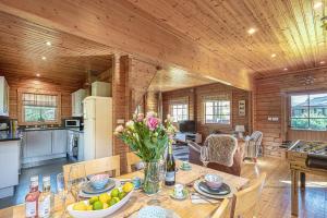 a kitchen and dining room with a table with flowers at Scandi Cabin in Heart of Anglesey with Parking in Llanfairpwllgwyngyll