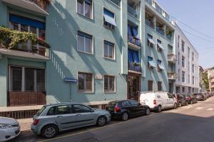 een blauw gebouw met auto's voor het gebouw bij GuestHost - Bullona Bright & Design Apt - M5 Gerusalemme in Milaan
