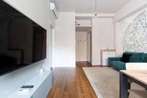 een woonkamer met een bank en een tv bij GuestHost - Bullona Bright & Design Apt - M5 Gerusalemme in Milaan