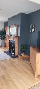 a living room with blue walls and a fireplace at Bernie’s Place in Ballyliffin