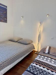 1 dormitorio con 2 camas individuales y lámpara en Petit nid cosy au cœur du Puy 1 à 5 personnes en Le Puy-en-Velay