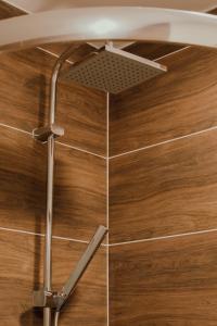 een douche in een badkamer met een metalen douchekop bij Apartmán EMILY in Brezno
