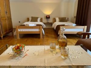 a room with two beds and a table with a bottle of wine at InterInn Luxury Villa in Paraćin
