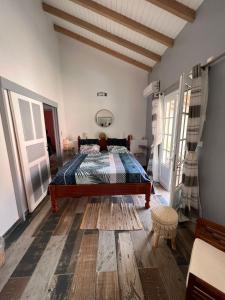 um quarto com uma cama e piso em madeira em Bekeke em Capesterre