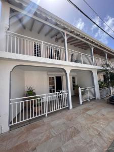 a white house with a balcony and a patio at Bekeke in Capesterre-de-Marie-Galante
