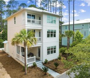 an aerial view of a white house with palm trees at Scissortail at Treetop in Santa Rosa Beach