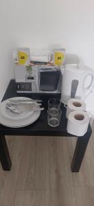 a table with a counter top with a microwave and dishes at H8 Room 2 Quiet place with 15 min walk to City Centre, Free car parking, Late night Checkin Anytime ,2min walk to bus stop in Manchester