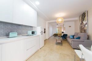 a kitchen and a living room with a couch at Precioso loft El Arcángel junto a la Ribera in Córdoba