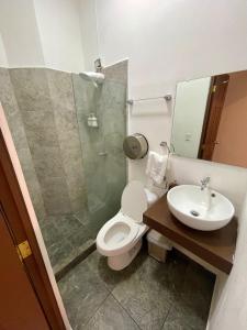 a bathroom with a toilet and a sink and a shower at Hotel y Café Ixmati Suchitoto in Suchitoto