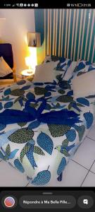 - un lit avec une couette bleue et blanche dans l'établissement studio Aude, à Lézignan-Corbières