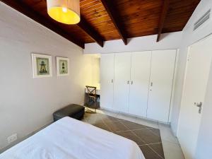 sypialnia z białymi szafkami i łóżkiem w obiekcie San Lameer Villa 2112 w mieście Southbroom