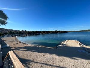a view of a beach next to a body of water at Apartments Dado Trogir in Trogir