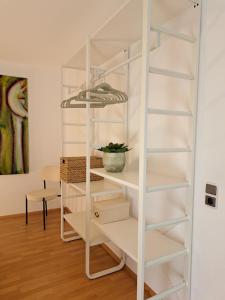 a white book shelf in a room with a table at Art & Living House in Schoneck