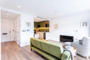 uma sala de estar com um sofá e duas cadeiras em Modern Chelsea Apartment em Londres