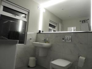 a bathroom with a sink and a toilet and a mirror at Cheerful 3 bed in the heart of Fethard village in Fethard on Sea