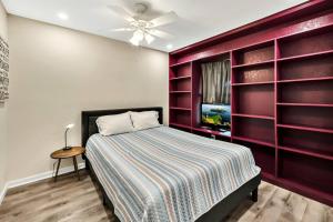 - une chambre avec un lit et un mur rouge dans l'établissement New Cozy Retreat Located 15 minutes to Waco, à Hewitt