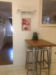 a kitchen with a wooden table and two stools at AGAPEE in Aix-en-Provence