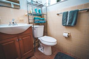 a bathroom with a toilet and a sink and towels at Hollywood Light Haven Lodge in Hollywood