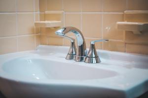 a bathroom sink with a chrome faucet on it at Hollywood Light Haven Lodge in Hollywood