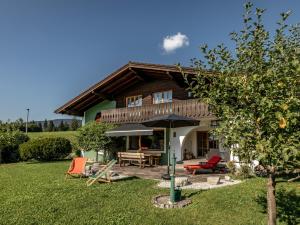 a house with a table and chairs and an umbrella at DasBeckHaus - Chiemgau Karte in Inzell