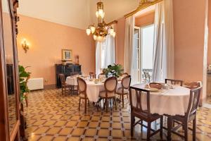 a dining room with tables and chairs and a chandelier at Palazzo Zacà in Gallipoli