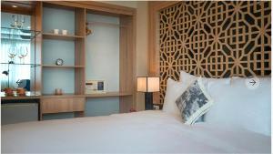 1 dormitorio con 1 cama blanca grande y escritorio en Gemini Saigon LUXURY en Ho Chi Minh