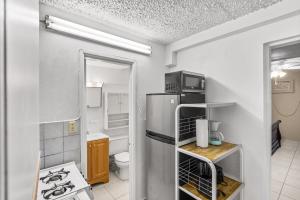 a small kitchen with a refrigerator and a microwave at Not only you have a view condo in Christiansted
