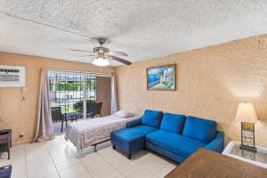 a living room with a blue couch and a bed at One Nice Caribbean View condo in Christiansted