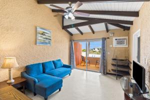 a living room with a blue couch and a ceiling fan at One blue Caribbean View condo in Christiansted