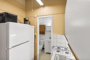 a small kitchen with a refrigerator and a toilet at One blue Caribbean View condo in Christiansted