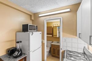 a small kitchen with a refrigerator and a microwave at Caribbean View condo in Christiansted